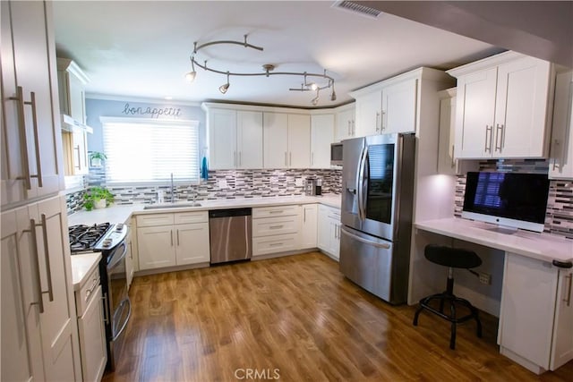 750 Durham St, La Habra, CA 90631 - kitchen with stainless steel appliances, light countertops, tasteful backsplash, white cabinets, and light wood finished floors