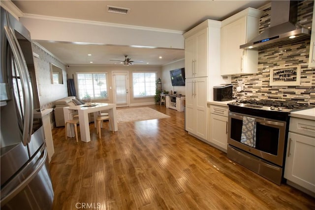 750 Durham St, La Habra, CA 90631 - kitchen with wall chimney range hood, appliances with stainless steel finishes, open floor plan, ornamental molding, and wood finished floors