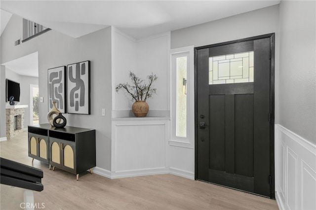 6923 Lamar Ct, Rancho Cucamonga, CA 91701 - entrance foyer featuring wood finished floors, a stone fireplace, and a wainscoted wall