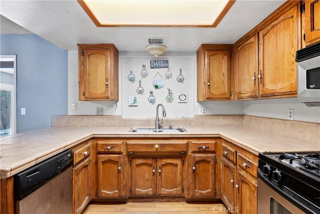 5013 Stancliff St, Bakersfield, CA 93307 - kitchen featuring appliances with stainless steel finishes, brown cabinets, a peninsula, and light wood-style flooring