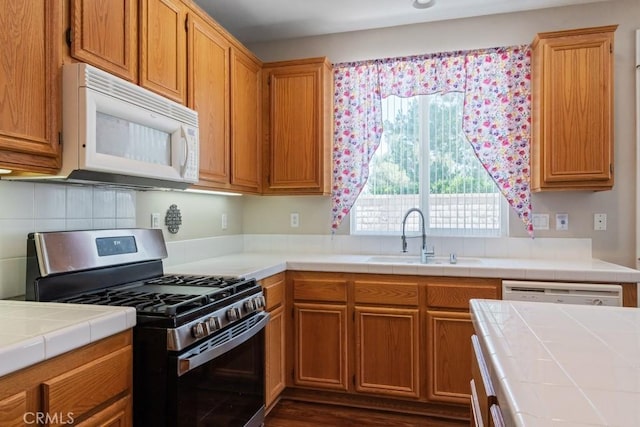 7704 Couples Way, Hemet, CA 92545 - kitchen with white appliances, tile countertops, tasteful backsplash, brown cabinetry, and dark wood-style floors