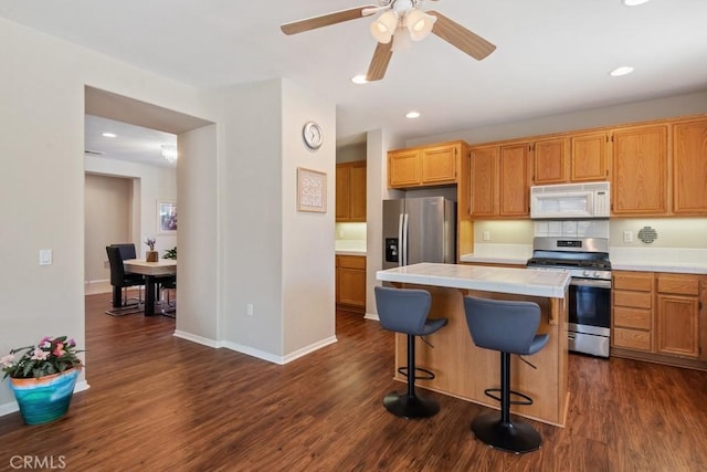 7704 Couples Way, Hemet, CA 92545 - kitchen featuring stainless steel appliances, tile countertops, dark wood finished floors, a center island, and recessed lighting