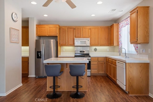 7704 Couples Way, Hemet, CA 92545 - kitchen with appliances with stainless steel finishes, tile countertops, dark wood-style floors, a kitchen island, and a ceiling fan