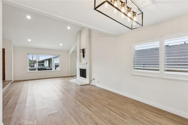 740 Great Bend Dr, Diamond Bar, CA 91765 - unfurnished living room with light wood-style floors, a brick fireplace, lofted ceiling, recessed lighting, and a chandelier
