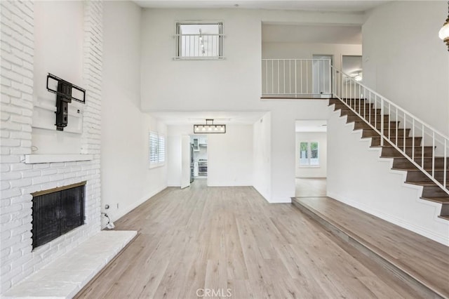 740 Great Bend Dr, Diamond Bar, CA 91765 - unfurnished living room featuring a high ceiling, stairway, healthy amount of natural light, wood finished floors, and a fireplace