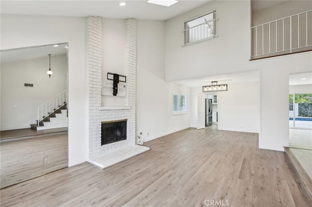 740 Great Bend Dr, Diamond Bar, CA 91765 - unfurnished living room with a towering ceiling, wood finished floors, stairs, a fireplace, and recessed lighting