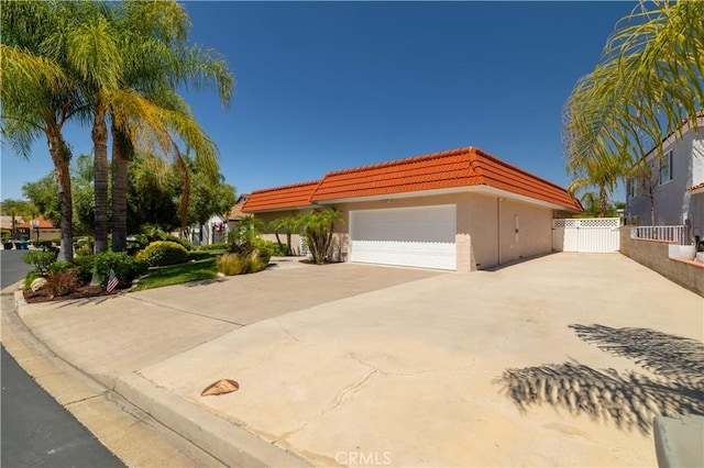 30221 Lands End Pl, Canyon Lake, CA 92587 - view of front of house with driveway, a tiled roof, an attached garage, and stucco siding