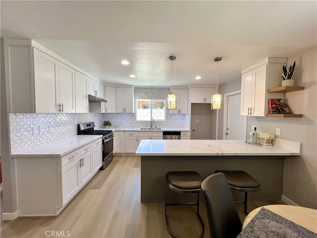 1626 S Pacific Ave, Santa Ana, CA 92704 - kitchen with stainless steel appliances, a peninsula, under cabinet range hood, open shelves, and a breakfast bar area