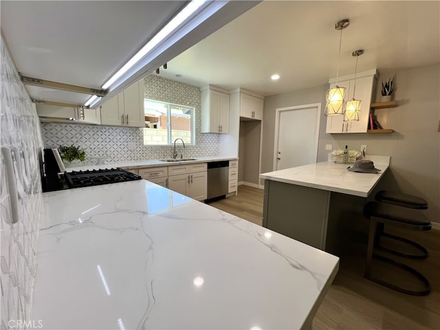 1626 S Pacific Ave, Santa Ana, CA 92704 - kitchen featuring stainless steel dishwasher, a peninsula, range with gas cooktop, light stone countertops, and decorative backsplash