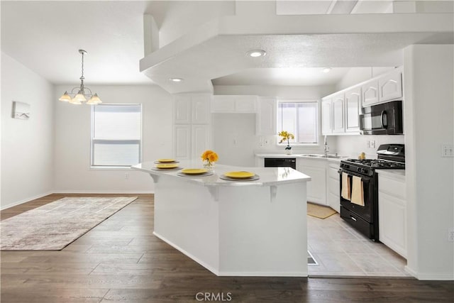 20197 Canyon View Dr, Canyon Country, CA 91351 - kitchen featuring black appliances, healthy amount of natural light, light wood finished floors, and white cabinets