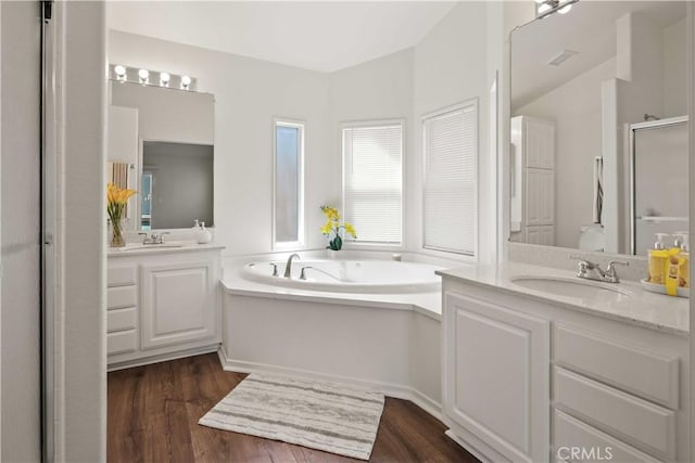 20197 Canyon View Dr, Canyon Country, CA 91351 - bathroom featuring a stall shower, two vanities, a garden tub, and wood finished floors