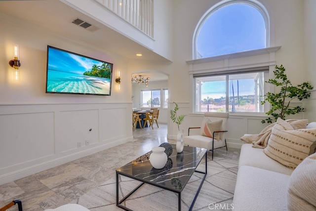 23851 Catamaran Way Unit 1, Laguna Niguel, CA 92677 - living area featuring a decorative wall, a chandelier, a wainscoted wall, a towering ceiling, and arched walkways