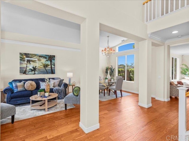 2381 Avenida Helecho, Carlsbad, CA 92009 - living room with a chandelier, light wood-style flooring, a high ceiling, and decorative columns