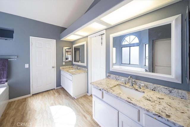 5963 Rio Valle Dr, Bonsall, CA 92003 - bathroom featuring two vanities and wood finished floors