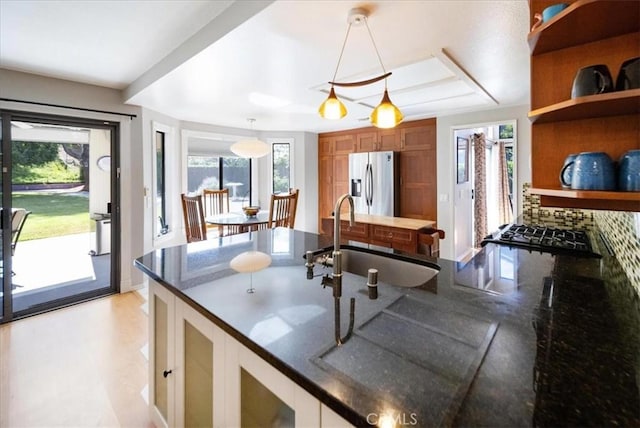 5963 Rio Valle Dr, Bonsall, CA 92003 - kitchen featuring stainless steel fridge with ice dispenser, open shelves, pendant lighting, dark stone countertops, and gas cooktop