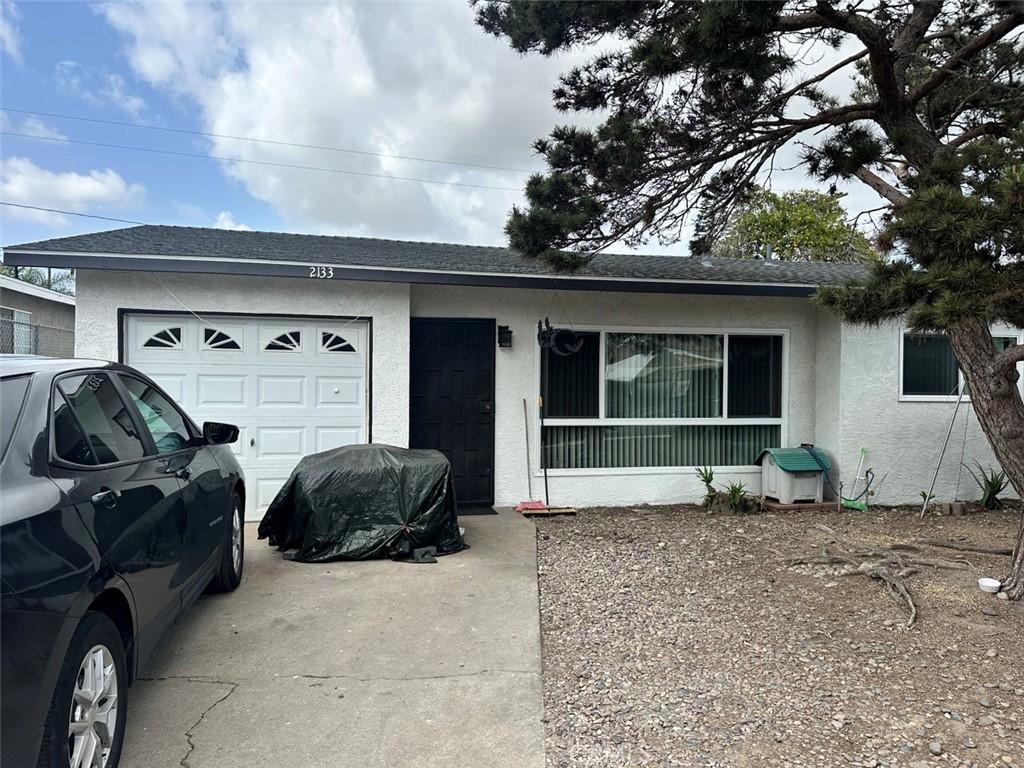 2133 E Lucien St, Compton, CA 90222 - view of front of property with stucco siding, an attached garage, driveway, and a shingled roof