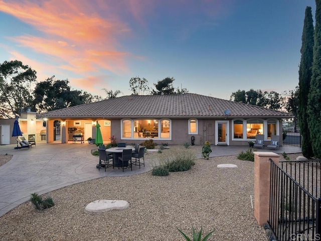 31755 Rancho Vista Rd, Temecula, CA 92592 - back of property at dusk with a tile roof, stucco siding, and a patio