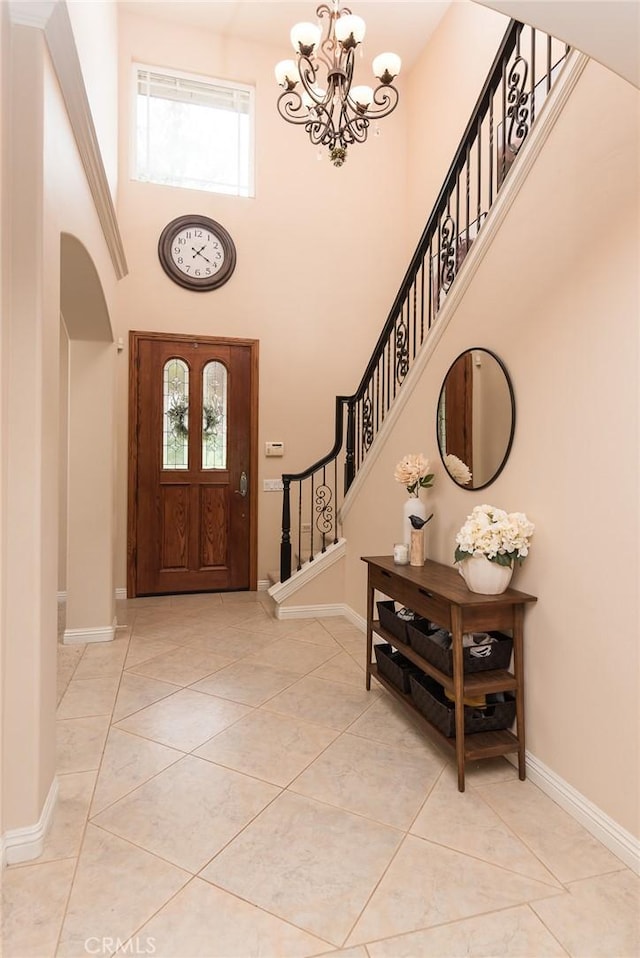 25919 Matlin Rd, Ramona, CA 92065 - entrance foyer with arched walkways, a chandelier, a towering ceiling, stairway, and light tile patterned flooring