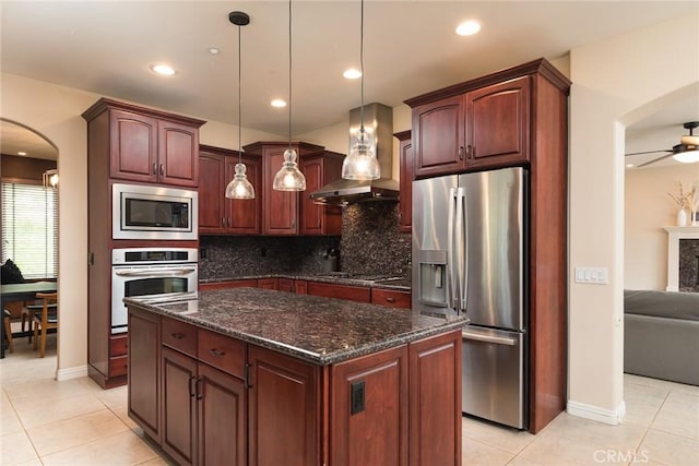 25919 Matlin Rd, Ramona, CA 92065 - kitchen featuring appliances with stainless steel finishes, wall chimney exhaust hood, arched walkways, tasteful backsplash, and light tile patterned floors