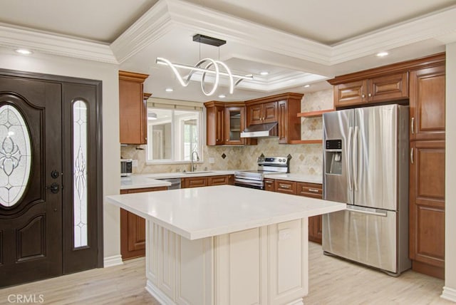 767 Calle Aragon Unit A, Laguna Woods, CA 92637 - kitchen featuring appliances with stainless steel finishes, under cabinet range hood, ornamental molding, light countertops, and light wood-type flooring