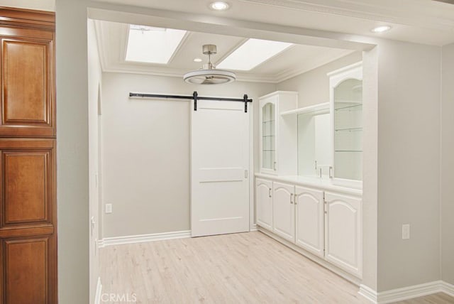 767 Calle Aragon Unit A, Laguna Woods, CA 92637 - spacious closet featuring a barn door, light wood-type flooring, and a skylight