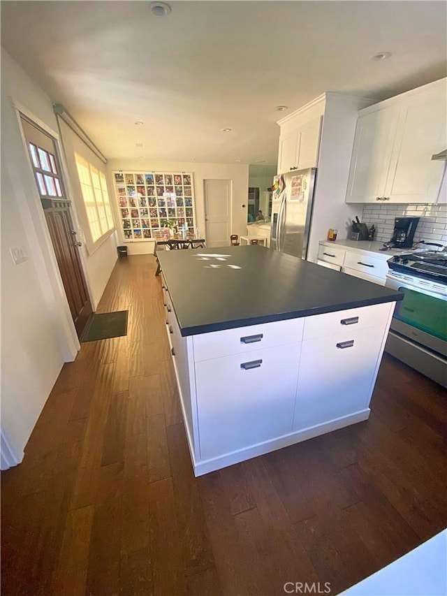 143 Warren Ave, Santa Paula, CA 93060 - kitchen with appliances with stainless steel finishes, dark wood finished floors, white cabinets, dark countertops, and a center island