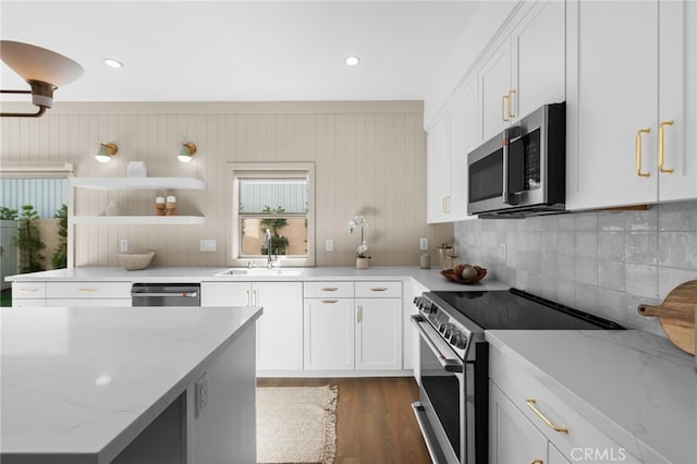 16221 Orizaba Ave, Paramount, CA 90723 - kitchen with appliances with stainless steel finishes, white cabinetry, wood finished floors, decorative backsplash, and light stone countertops