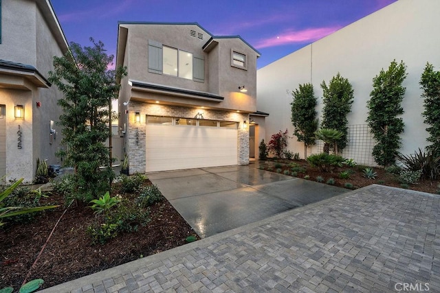 16221 Orizaba Ave, Paramount, CA 90723 - view of front of home featuring an attached garage, concrete driveway, stone siding, and stucco siding