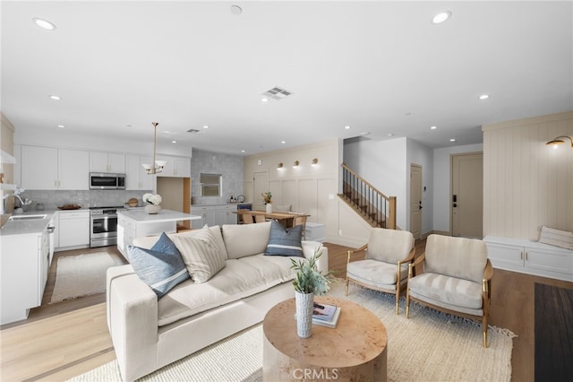 16221 Orizaba Ave, Paramount, CA 90723 - living room featuring stairs, light wood finished floors, recessed lighting, and a decorative wall
