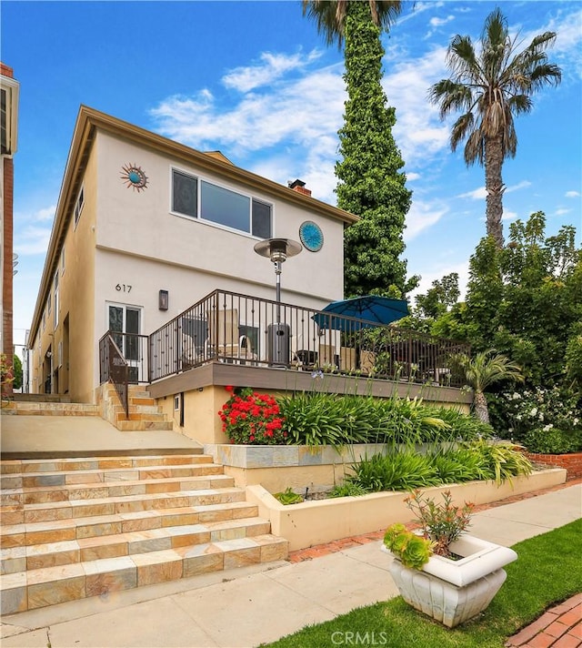 617 Iris Ave, Corona Del Mar, CA 92625 - back of house featuring stucco siding, stairway, a deck, and a chimney