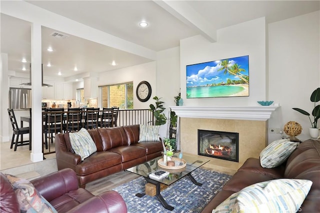 617 Iris Ave, Corona Del Mar, CA 92625 - living area featuring decorative columns, a fireplace, beam ceiling, light tile patterned floors, and recessed lighting