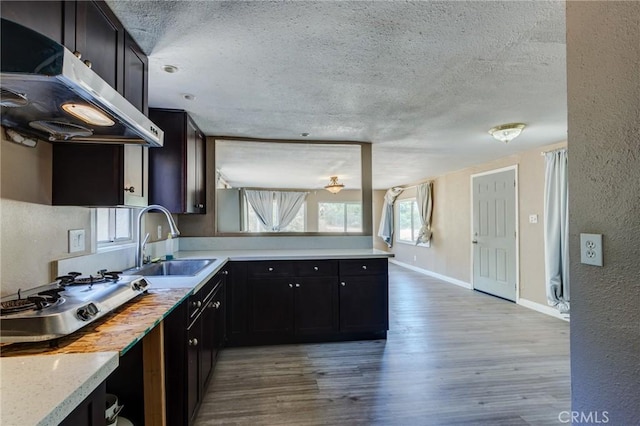 35050 Margo Rd, Lake Elsinore, CA 92530 - kitchen with exhaust hood, a textured ceiling, a textured wall, light wood-style floors, and light countertops