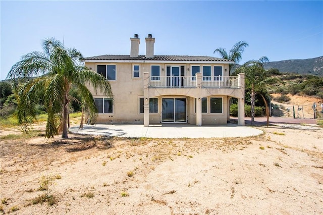 35050 Margo Rd, Lake Elsinore, CA 92530 - rear view of property featuring a balcony, a chimney, a patio, and stucco siding