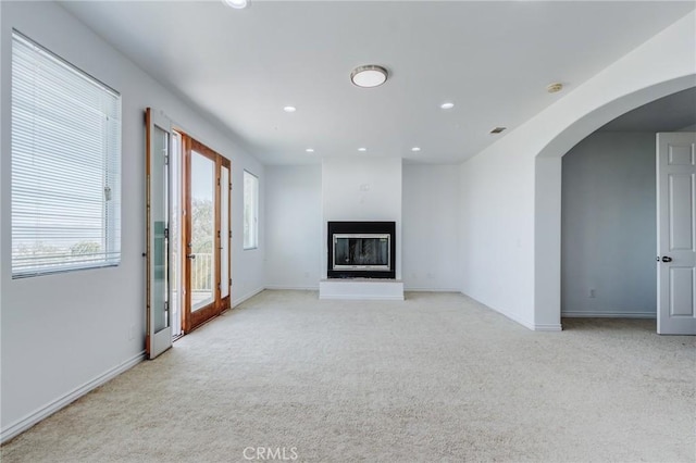 35050 Margo Rd, Lake Elsinore, CA 92530 - unfurnished living room with light carpet, arched walkways, recessed lighting, and a glass covered fireplace