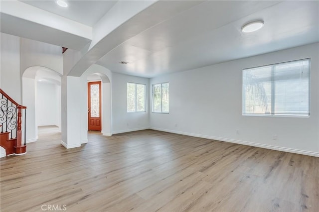 35050 Margo Rd, Lake Elsinore, CA 92530 - empty room with arched walkways, light wood-type flooring, and stairway