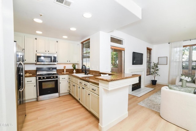 307 E Walnut Ave Unit D, Monrovia, CA 91016 - kitchen with appliances with stainless steel finishes, a peninsula, light wood finished floors, dark stone countertops, and recessed lighting