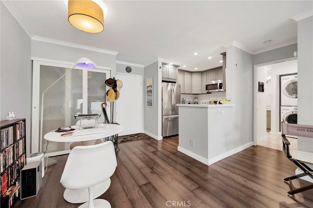 1118 Valencia St Unit 120, Los Angeles, CA 90015 - kitchen featuring stacked washer and clothes dryer, appliances with stainless steel finishes, dark wood-type flooring, crown molding, and tasteful backsplash