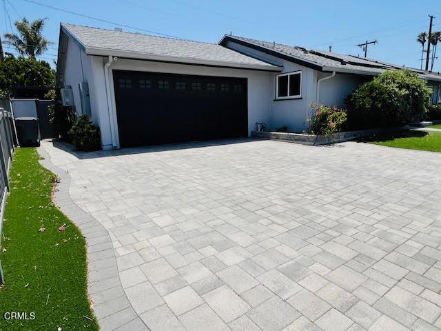 1900 Piedmont St, Oxnard, CA 93035 - ranch-style house featuring an attached garage, decorative driveway, solar panels, and stucco siding