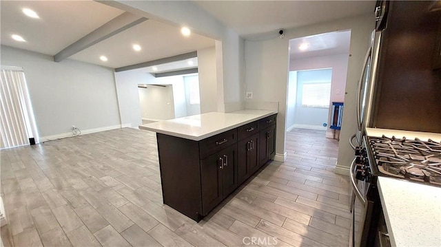 8649 Cantaloupe Ave, Panorama City, CA 91402 - kitchen with stainless steel appliances, light countertops, light wood-style flooring, beamed ceiling, and a peninsula