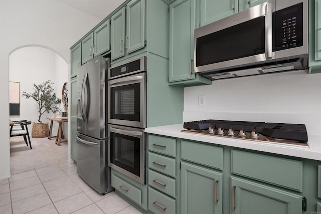 3649 Azure Cir, Carlsbad, CA 92008 - kitchen with green cabinets, stainless steel appliances, light countertops, light colored carpet, and light tile patterned flooring