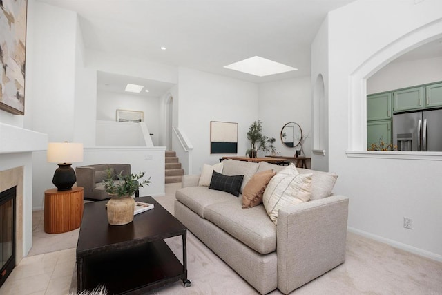 3649 Azure Cir, Carlsbad, CA 92008 - living room featuring a glass covered fireplace, a skylight, arched walkways, recessed lighting, and light carpet