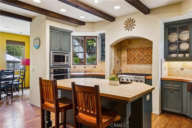 935 Isabella Way, San Luis Obispo, CA 93405 - kitchen featuring wood counters, appliances with stainless steel finishes, beamed ceiling, a breakfast bar area, and light wood-style flooring