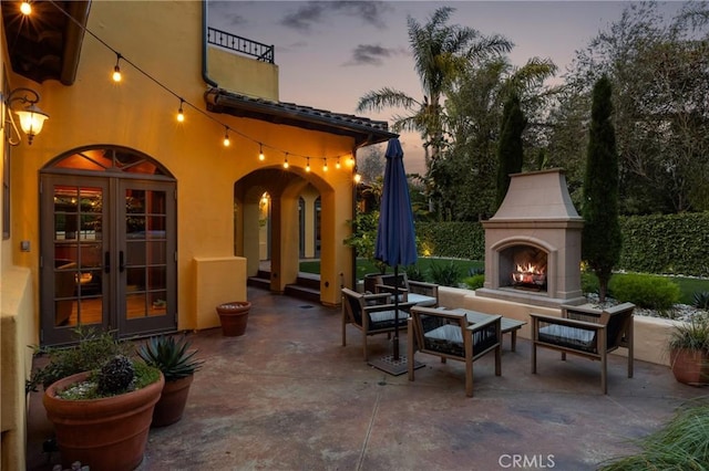 935 Isabella Way, San Luis Obispo, CA 93405 - patio terrace at dusk featuring a patio, french doors, and an outdoor living space with a fireplace