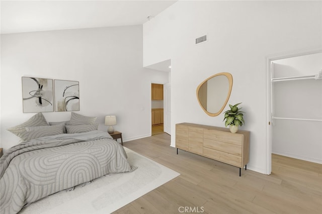6041 Calle Mirador, Yorba Linda, CA 92886 - bedroom with high vaulted ceiling, a walk in closet, and light wood-style flooring
