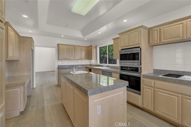 6041 Calle Mirador, Yorba Linda, CA 92886 - kitchen with appliances with stainless steel finishes, light brown cabinetry, a center island with sink, a raised ceiling, and backsplash