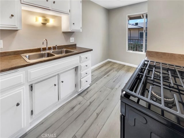 1920 N H St Unit 251, Oxnard, CA 93036 - kitchen with gas range oven, light wood-type flooring, and white cabinets