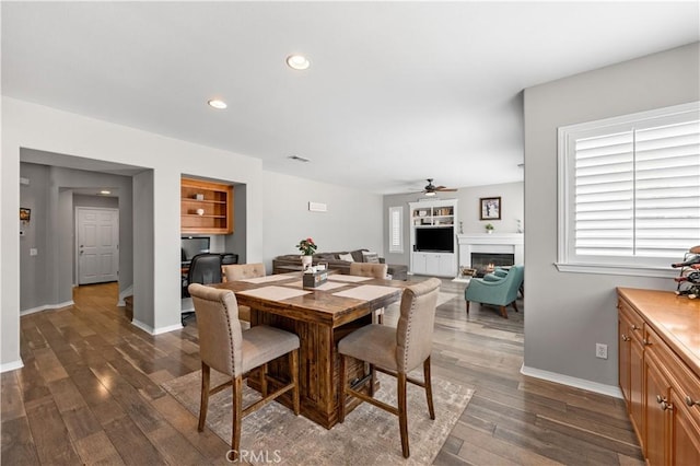 42639 Biscay, Lancaster, CA 93536 - dining room with a ceiling fan, dark wood-style flooring, a lit fireplace, and recessed lighting