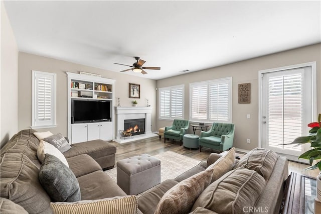 42639 Biscay, Lancaster, CA 93536 - living room with wood finished floors, a ceiling fan, and a glass covered fireplace