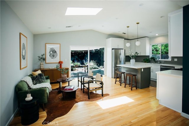 17442 Burma St, Encino, CA 91316 - living area featuring a skylight, light wood finished floors, lofted ceiling, and recessed lighting
