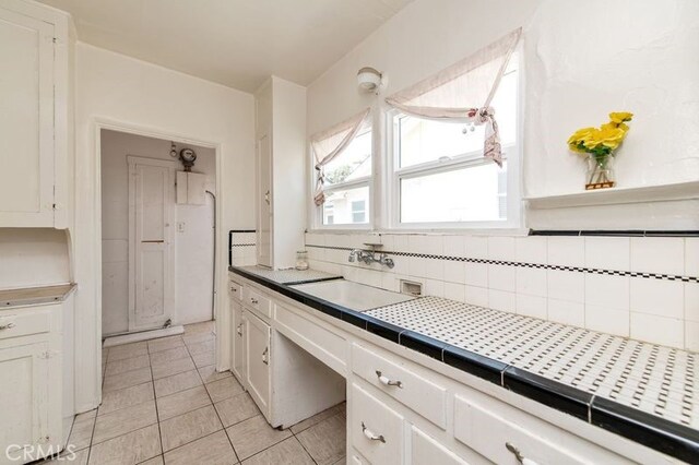 329 N Bushnell Ave, Alhambra, CA 91801 - kitchen with light tile patterned floors, white cabinets, tasteful backsplash, and tile counters